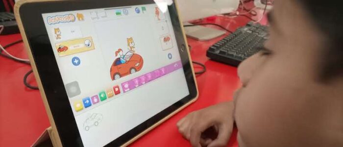 Kid at MySchool Jhang exploring Scratch Junior for interactive programming and storytelling.